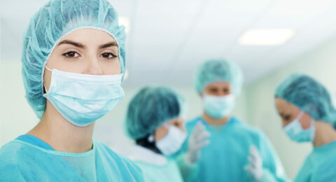 Young female surgeon with medical team in back before surgery